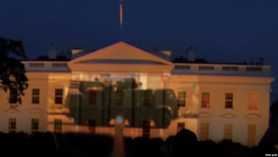 A screen grab from a video posted on YouTube that seemingly shows images of Russian military vehicles projected onto the facade of the White House.