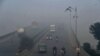 Commuters drive in heavy smog conditions in Lahore on November 21. 