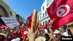 Demonstranti drže vekne hljeba dok protestuju protiv referenduma o novom ustavu koji je raspisao predsjednik Kais Saied, u Tunisu, Tunis, 18. juna 2022. 