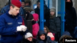 Hungarian police guard Kosovar migrants after they illegally crossed the Hungarian-Serbian border in early February.