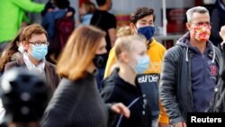 Disa qytetarë ecin me maska mbrojtëse në Gjermani. 