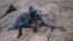 Masked Sunni gunmen take positions with their weapons during clashes with Iraqi security forces outside the city of Fallujah on January 23.