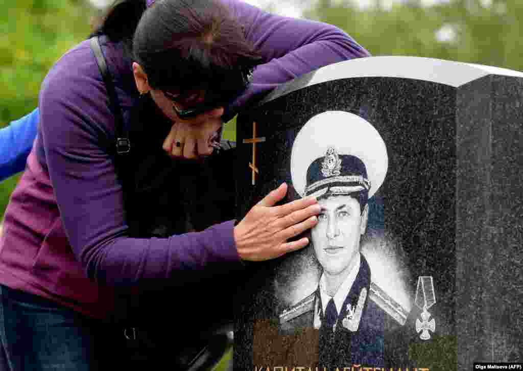 Relatives visit the graves of those who died in the Kursk submarine disaster during a memorial ceremony on the 20th anniversary of the tragedy at St. Petersburg&#39;s Serafimov cemetery on August 12. (AFP/Olga Maltseva)