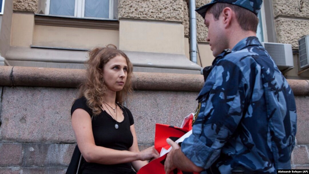 Russian activist of the feminist protest group Pussy Riot Maria Alyokhina talks to a policeman as she holds a protest in front of the FSIN building in Moscow on August 7.