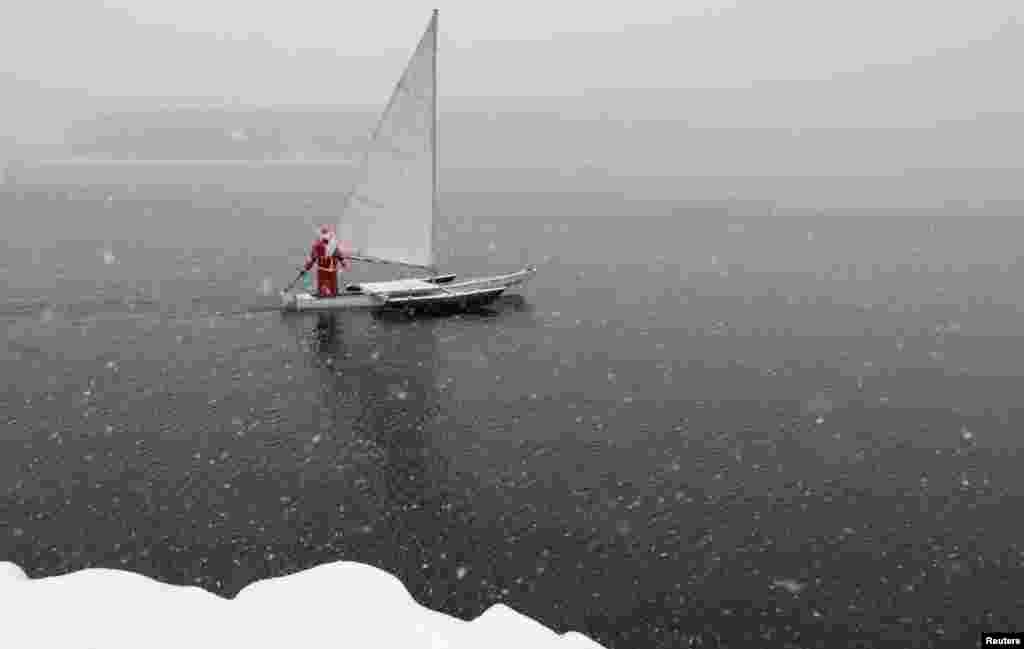 A sailing enthusiast dressed as Santa Claus sails his trimaran to mark the ending of the sailboat season during heavy snowfall on the Yenisei River outside Krasnoyarsk, Russia. (Reuters/Ilya Naymushin)