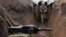 UKRAINE -- A Ukrainian serviceman walks in a trench as he stands at his post on the frontline with Russia backed separatists near the town of Zolote, in the Luhansk region, April 8, 2021