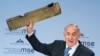 Israeli Prime Minister Benjamin Netanyahu holds up an object, which he claimed was a piece of an Iranian drone shot down in Israeli airspace, during his speech at the Munich Security Conference on February 18. 