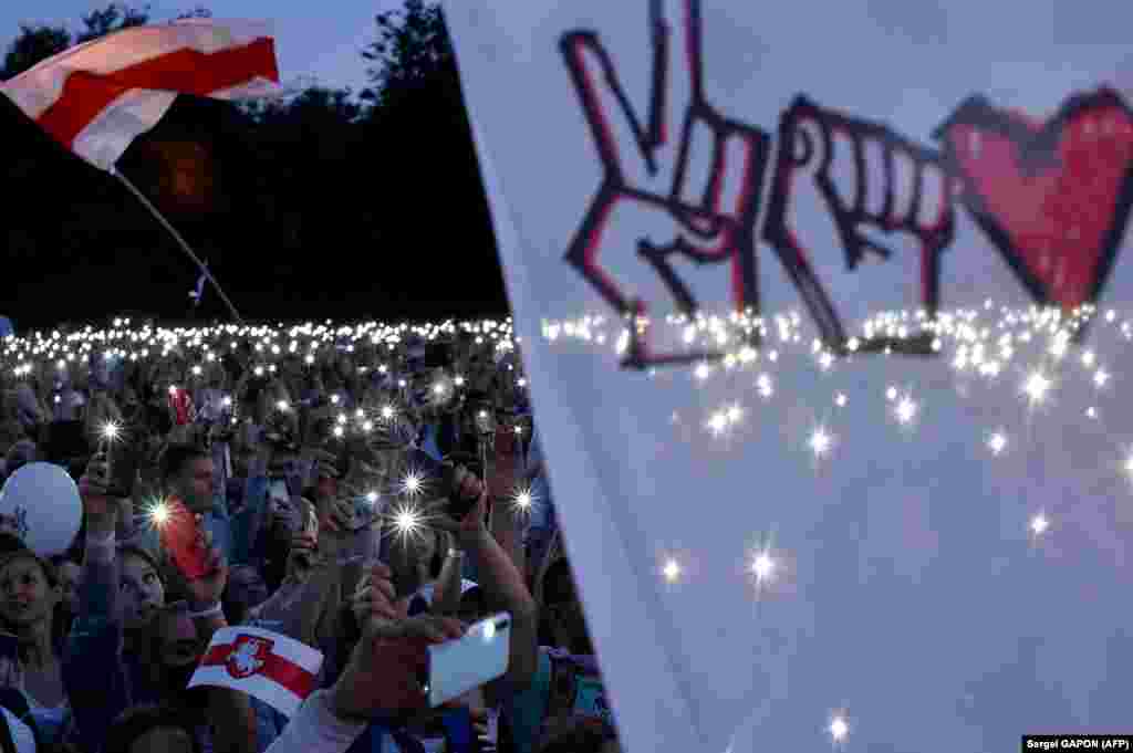 Supporters of Belarusian opposition presidential candidate Svyatlana Tsikhanouskaya turn on the flashlights on their smartphones during a campaign rally in Minsk. (AFP/Sergei Gapon)