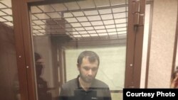 Timur Kishukov in an enclosure in a Russian courtroom