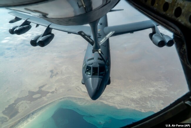 Американский стратегический бомбардировщик-ракетоносец B-52 "Суперкрепость" заправляется в воздухе с помощью авиазаправщика КС-135 "Стратотанкер" в небе над Персидским заливом. 30 декабря 2020 года