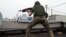 A pro-Russia militant shoots from a roof of a residential building at border guards defending the Federal Border Headquarters building in Luhansk on June 2.