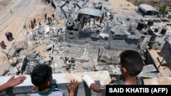 Palestinieni inspectând casele lor distruse de bombardamente israeliene în orașul Rafah, din sudul Fâșiei Gaza, 16 mai 2021.
