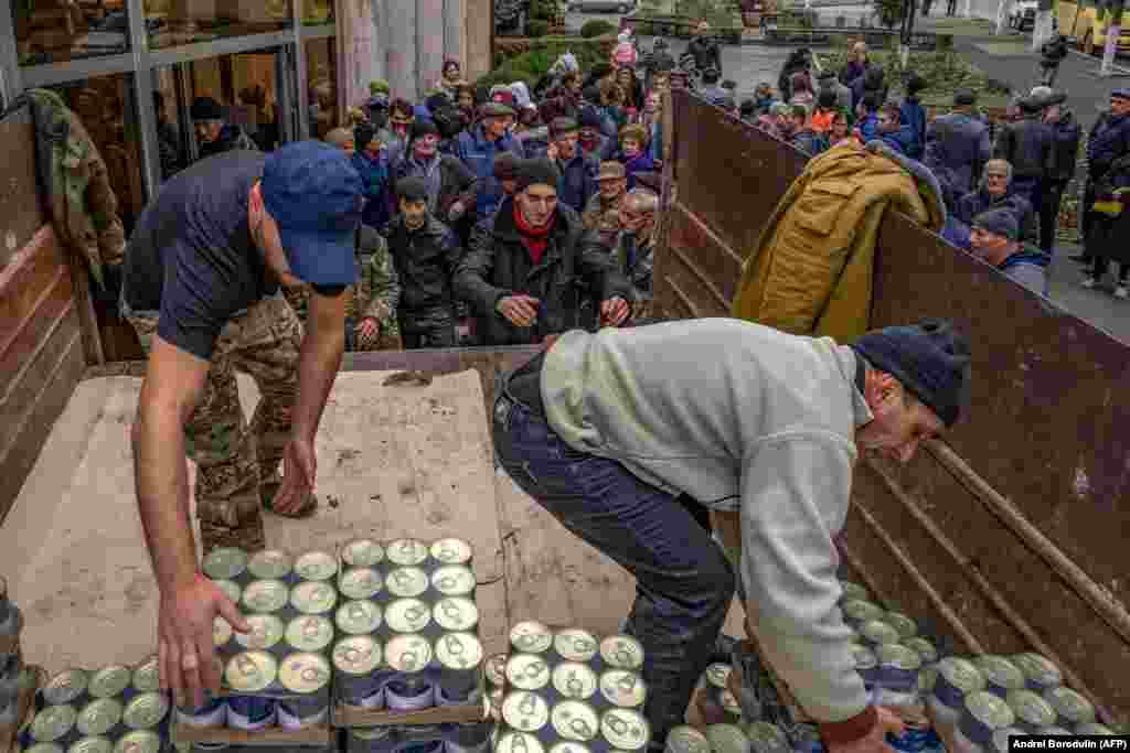 Чоловіки розвантажують вантажівку з продовольчою допомогою місцевим жителям. Фото від 22 листопада