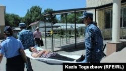 Транспортировка конвойными заключенной Гаухар Худабаевой по территории больницы, куда ее доставили на обследование. Алматинская область, 20 июня 2019 года.