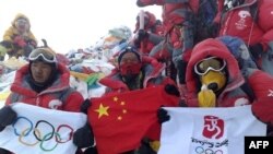 صعودکنندگان قرمز پوش پس از رسيدن به قله برفپوش اورست پرچم های چين و المپيک را گشودند و رو به دوربين ها فرياد کشيدند: زنده باد چين، زنده باد تبت. (عکس از AFP)
