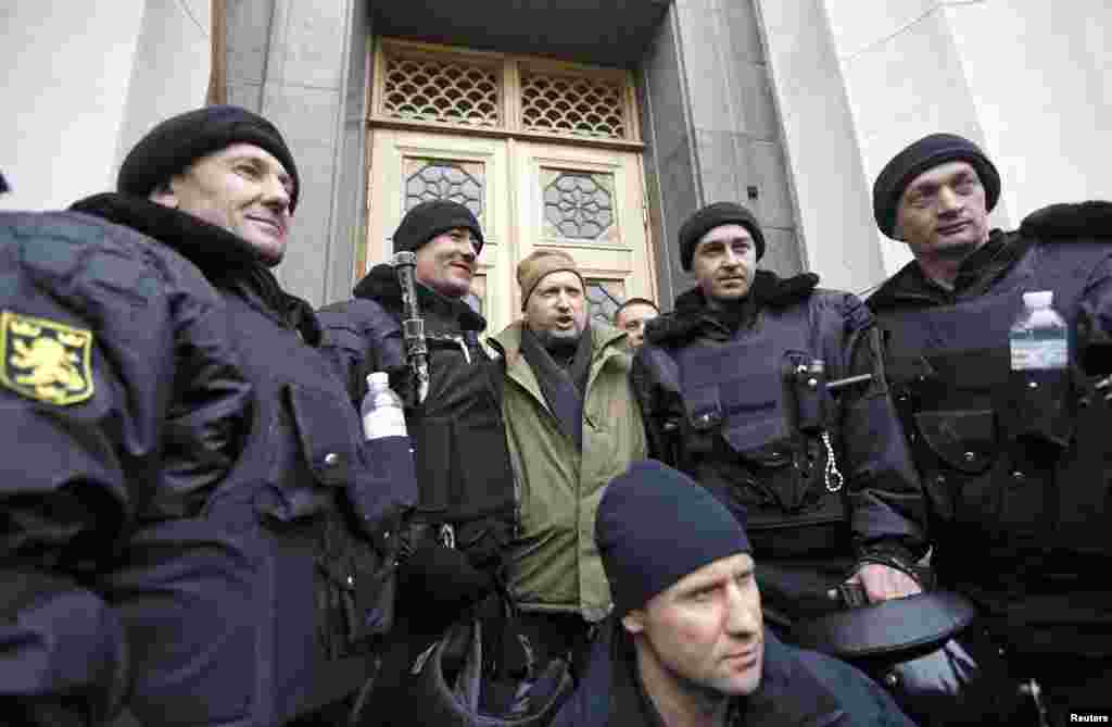 Newly-elected speaker of parliament Oleksandr Turchynov poses for a picture with a group of antigovernment protesters outside the Ukrainian parliament building.