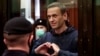 Aleksej Navalni gestikulira svojoj ženi iz staklene ćelije tokom sudskog ročišta u Moskvi 2. februara 2021.