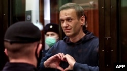 Aleksej Navalni gestikulira svojoj ženi iz staklene ćelije tokom sudskog ročišta u Moskvi 2. februara 2021.