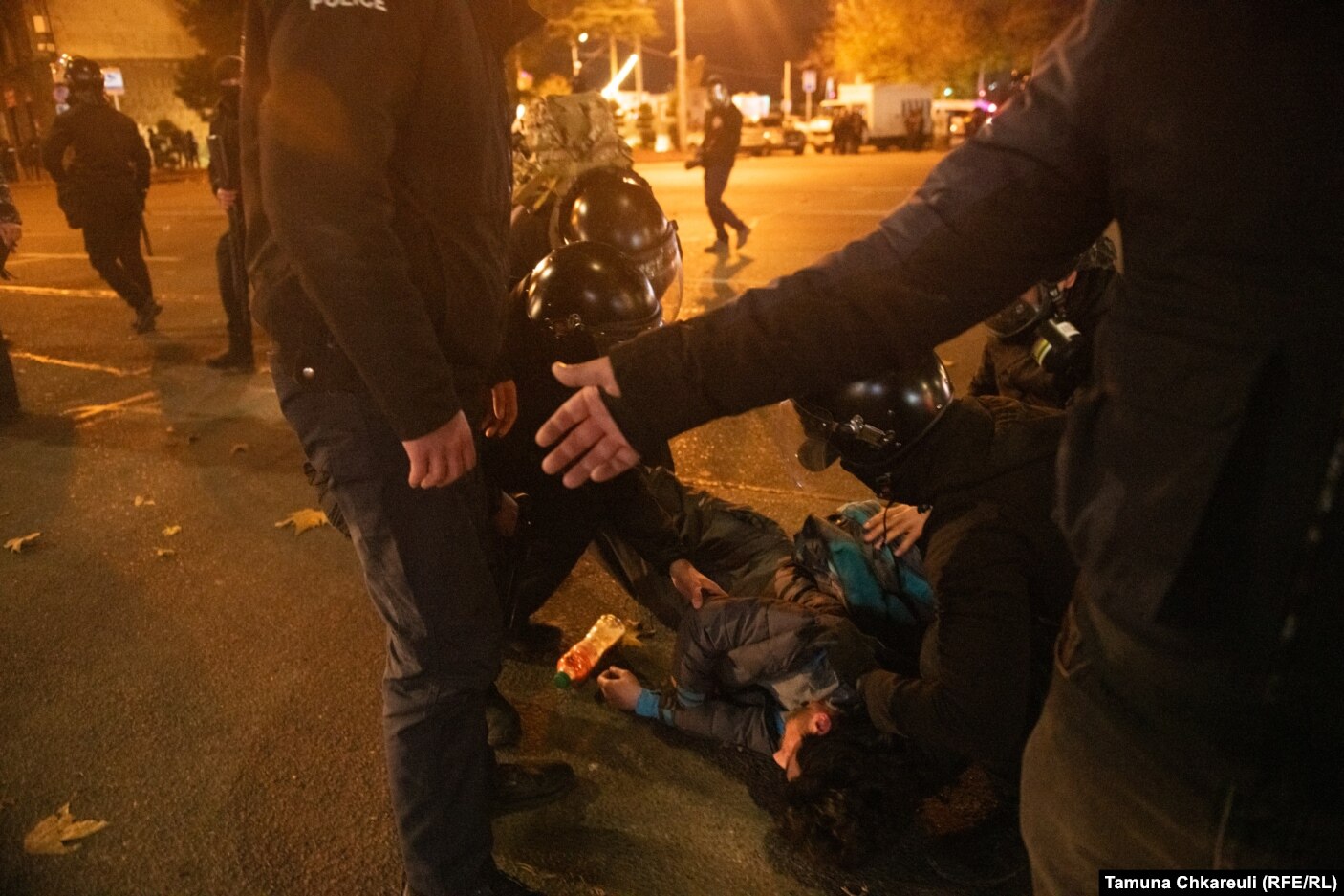 Policët duke e rrethuar një burrë të plagosur në Rustaveli në orët e hershme të 29 nëntorit.