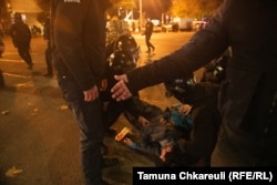 Police surround an injured man on Rustaveli early on the morning of November 29.