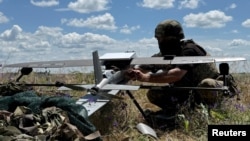 Un militar ucrainean se pregătește să lanseze o dronă de atac Hornet, de producție americană, în regiunea Donețk, Ucraina, iunie 2026.