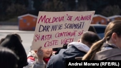O activistă cu o pancartă, în timpul Marșului Feminist de la Chișinău, 8 martie 2026