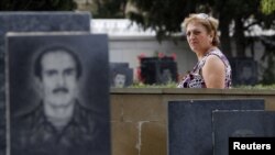 Azerbaijan -- A woman walks past tombstones with portraits of Azeris killed during the fighting between Karabakh and Azerbaijan forces in 1993 in the Alley of Martyrs memorial cemetery in Baku, 08Sep2012