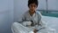 A wounded Afghan boy, a survivor of the U.S. air strikes on the MSF hospital in Kunduz, sits on his bed at a hospital in Kabul run by the Italian aid organization known as Emergency.