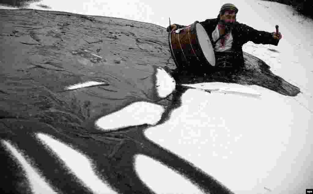 A man breaks the ice before celebrations of the Epiphany in the icy waters of the Tundzha River in Kalofer, Bulgaria. (epa/Vassil Donev)