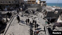  Палестинци ревизират мястото на израелски удар по жилищна постройка в Дейр ал Балах, 18 март 