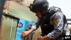 A security officer inspects the load of a pickup truck at a checkpoint in Baghdad on May 29.