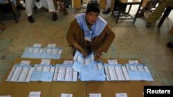 An election worker counts ballot papers at a polling station in Kandahar Province on September 18.