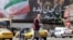Një burrë kalon një rrugë pranë një billboardi të madh politik përgjatë Sheshit Enghelab në qendër të Teheranit, më 26 maj 2026.