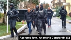 Police escort Romanian mercenary Horatiu Potra (center) in Bucharest on December 8.