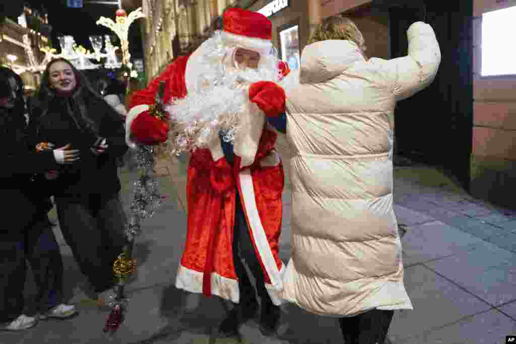 Muškarac obučen kao Djed Mraz i žena plešu tokom novogodišnje proslave u centru Sankt Peterburga, Rusija, 1. januara 2025.