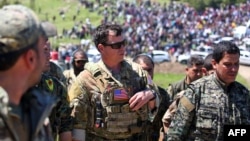 A U.S. officer, from the U.S.-led coalition, speaks with fighters from the Kurdish People's Protection Units (YPG) at the site of Turkish air strikes near the northeastern Syrian Kurdish town of Derik on April 25.