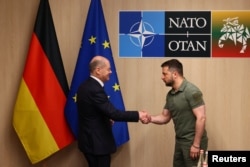 Президент України Володимир Зеленський і канцлер Німеччини Олаф Шольц зустрічаються під час саміту лідерів НАТО у Вільнюсі, Литва, 12 липня 2023 року.