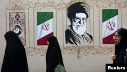 Women walk by a mural depicting Iran's late Supreme Leader Ayatollah Ali Khamenei in Tehran earlier this week. 