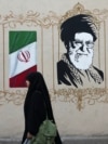 Women walk by a mural depicting Iran's late Supreme Leader Ayatollah Ali Khamenei in Tehran earlier this week. 