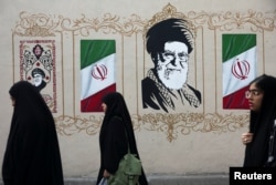 Women walk by a mural depicting Iran's late Supreme Leader Ayatollah Ali Khamenei in Tehran earlier this week.