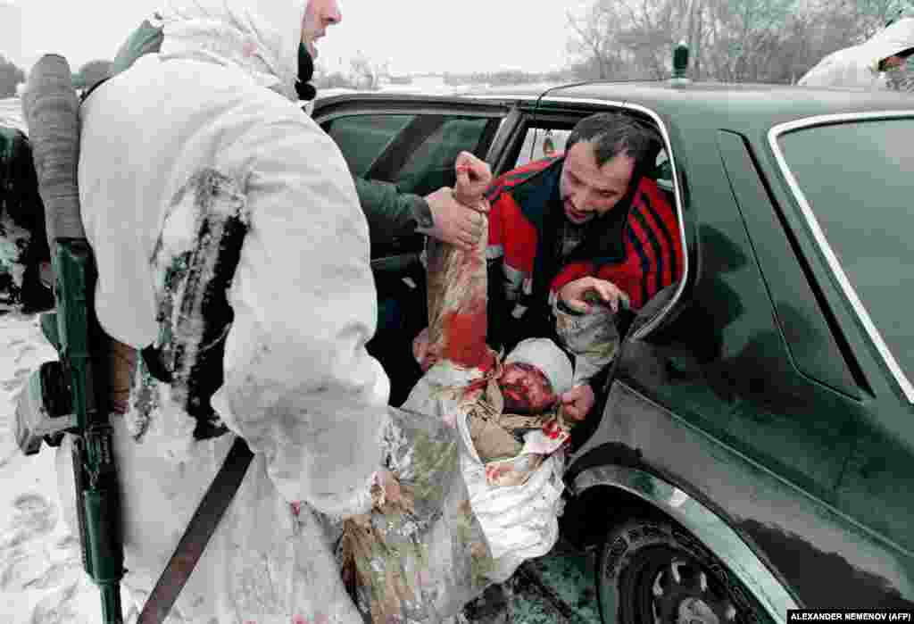 Чеченські бійці евакуюють пораненого товариша на автотранспорті, який із готовністю надають місцеві жителі. Професійних авто швидкої допомоги не вистачає. Шпиталі, школи, заводи, пекарні розбомблені. Грозний, 24 січня 1995 року