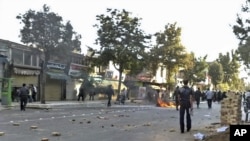 A motorbike is set on fire by protesters and rocks remain on the street during a protest in the northwestern city of Orumieh (Urmia) on August 27.