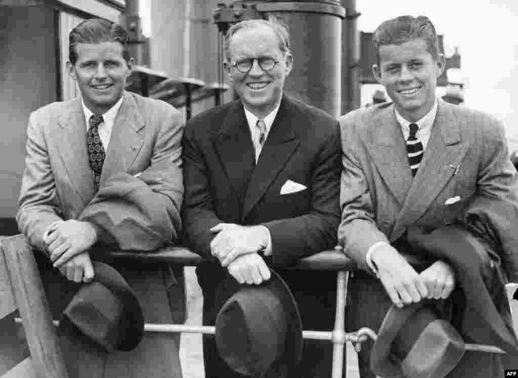 JFK (right) and his older brother, Joseph P. Kennedy, Jr. (left), beside their father, Joseph, in Southampton, England on the deck of French &quot;Normandy&quot; cruiser liner after their arrival from the United States on July 2, 1938. Joseph was later killed in action, in 1944, during World War II. 