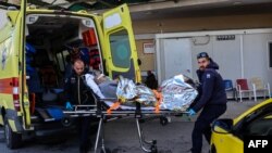 Ekipi mjekësor duke e bartur me barelë një të mbijetuar të anijes së fundosur në ishullin grek, Lesbos, për në spital më 26 nëntor 2023.