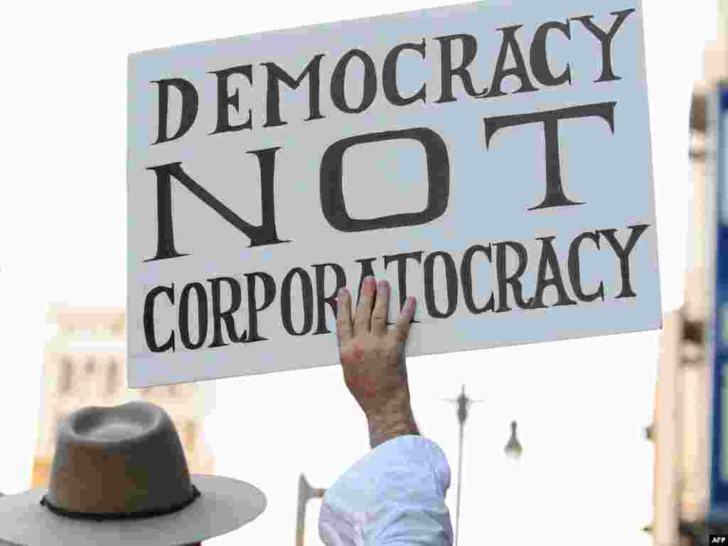 A protester holds a sign during a march through downtown Los Angeles on October 3. (Photo by&nbsp;Frederic J. Brown for AFP)