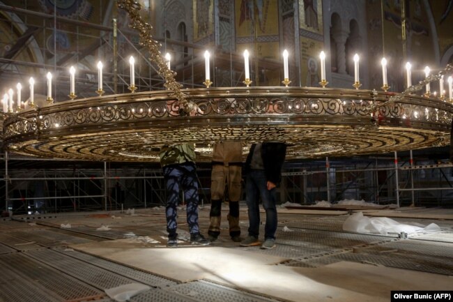Disa punëtorë punojnë në restaurimin e Kishës Ortodokse Shën Sava në Beograd të Serbisë.(AFP/Oliver Bunc)