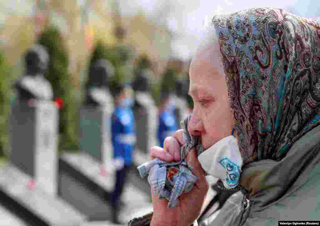 Една жена во Киев ги брише солзите за време на комеморативната церемонија во Чернобил.