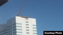 Binanın üstündə aksiya edən işçilər (Foto: Qafqazinfo)