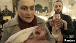 Infants cry during a mass baptism ceremony in Tbilisi in 2012.