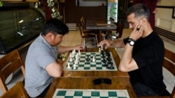Men play chess at the Cupcake Coffee Shop cafe in Kabul On May 11.